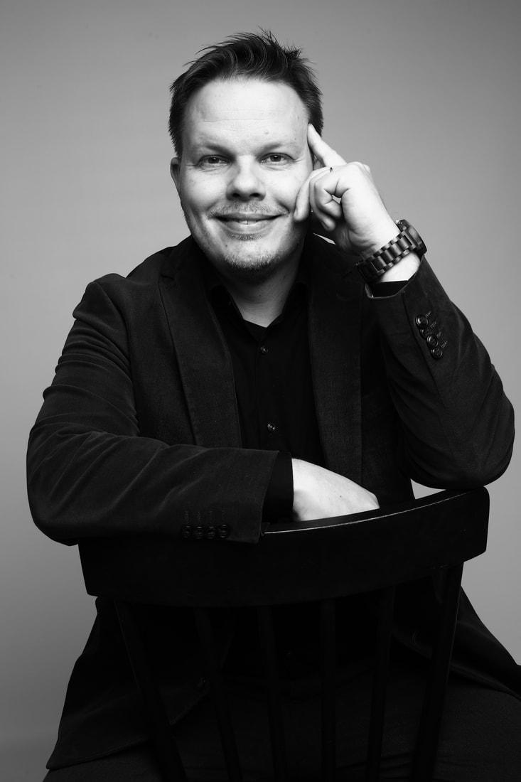 Författare Michael Wiander sitter på en stol.