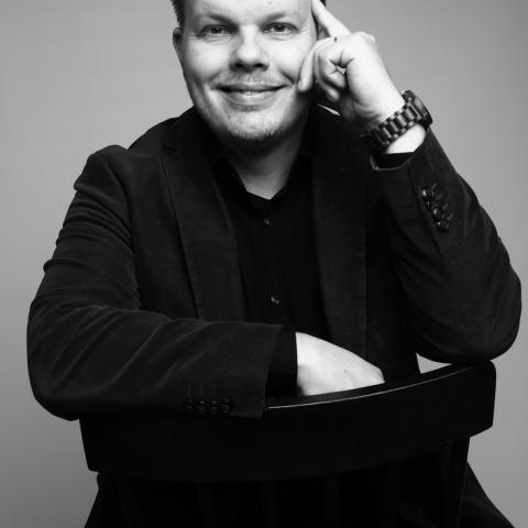 Författare Michael Wiander sitter på en stol.