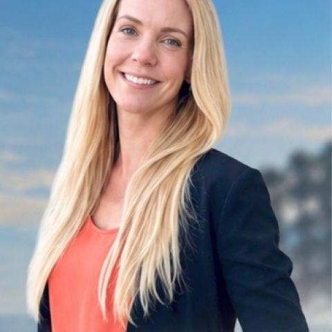 Författaren Sandra Öhman poserar mot en blå himmel.